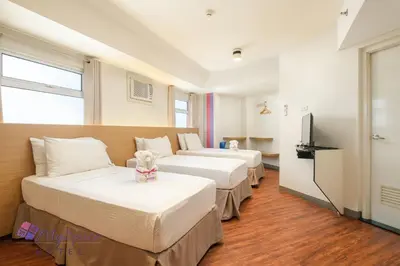 a hotel room with two beds and a television at MySpace Hotel @BGC in Manila