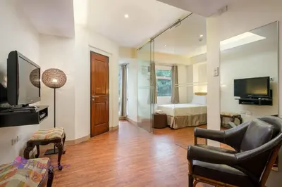 a living room with a room with a bed and a television at MySpace Hotel @BGC in Manila