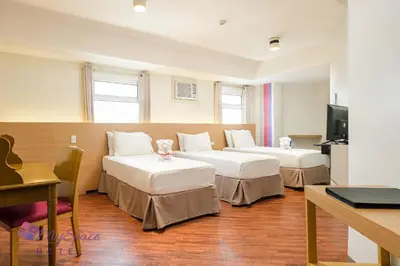 a hotel room with two beds and a table at MySpace Hotel @BGC in Manila