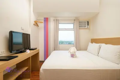 a hotel room with a bed and a television at MySpace Hotel @BGC in Manila