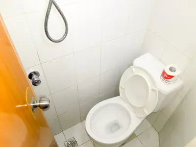 a bathroom with a toilet with a roll of toilet paper at 8Hostel in Manila