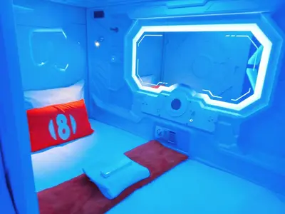 a room with a tv and a bed with a red pillow at 8Hostel in Manila