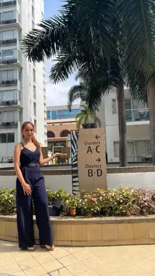 a woman is standing in front of a sign at 3N Palm Tree Villas in Manila