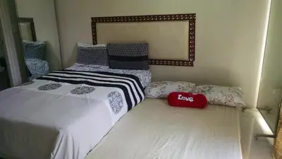 a bedroom with two twin beds and a mirror at 3N Palm Tree Villas in Manila