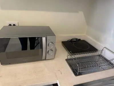 a microwave sitting on a kitchen counter next to a basket at Luxury suite next to Shangrila and Westin Hotels in Manila
