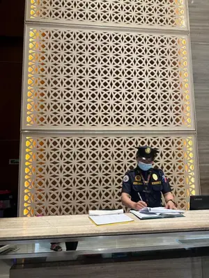 a police officer sitting at a table with at Luxury suite next to Shangrila and Westin Hotels in Manila