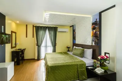 a hotel room with a bed and a desk at Eurotel Vivaldi Araneta in Manila