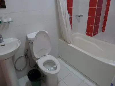 a white bathroom with a toilet and a sink at Eurotel Vivaldi Araneta in Manila
