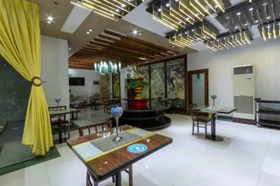 a dining room with a table and chairs and a fountain at Eurotel Vivaldi Araneta in Manila