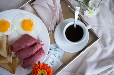 a plate of breakfast food with a cup of coffee at Eurotel Vivaldi Araneta in Manila