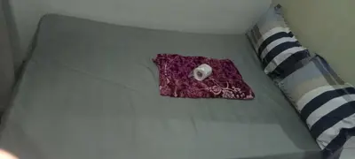 a purple object on a bed next to a pillow at Anna's Place at Sea Residences in Manila