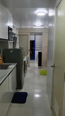 a kitchen with a refrigerator and a counter top at Anna's Place at Sea Residences in Manila