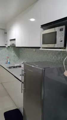 a kitchen with a stainless steel refrigerator and a microwave at Anna's Place at Sea Residences in Manila