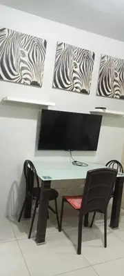 a desk with two chairs and a television on a wall at Anna's Place at Sea Residences in Manila