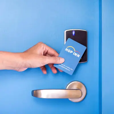 a person holding a blue card in a door at Hop Inn Hotel Ermita Manila in Manila