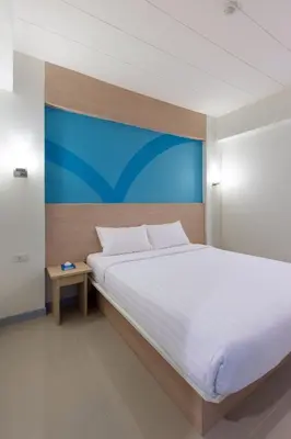 a bedroom with a large white bed and a table at Hop Inn Hotel Ermita Manila in Manila