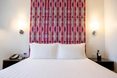 a bedroom with a bed with a red headboard at Wynwood Hotel in Manila