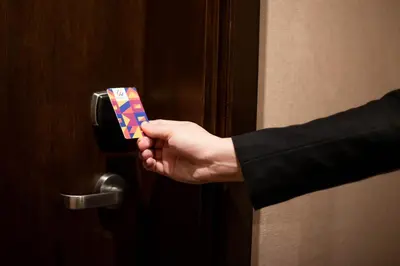 a hand is holding a piece of paper sticking out of a door at Wynwood Hotel in Manila