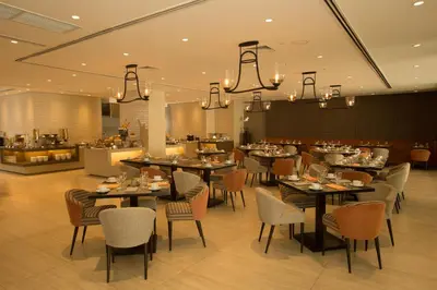 a dining room with tables and chairs and a restaurant at Wynwood Hotel in Manila