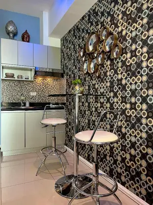a kitchen with two stools and a wall with pots and pans at The Beacon Residences Condominium in Manila