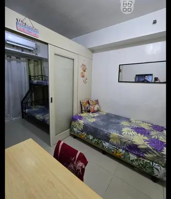 a small room with a bed and a table at FinkSea @ Sea Residences in Manila