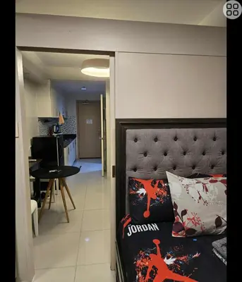 a view of a bedroom with a bed and a living room at FinkSea @ Sea Residences in Manila