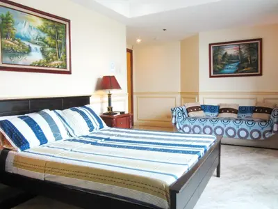 a bedroom with a large bed with blue and white pillows at Baywatch Tower in Manila
