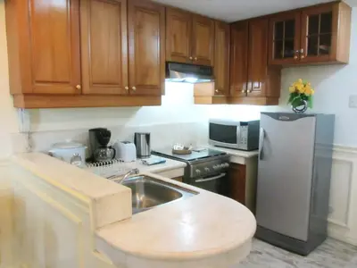 a kitchen with wooden cabinets and a stainless steel refrigerator at Baywatch Tower in Manila