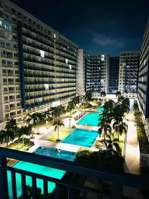 a view from a balcony of a hotel with two pools at Sea Residences MOA-Eric Apartments in Manila
