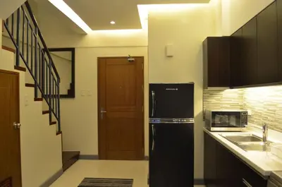 a kitchen with a black refrigerator and a sink at Eton Parkview in Manila