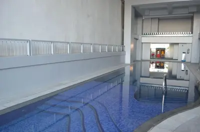 a swimming pool with blue water in a building at Eton Parkview in Manila