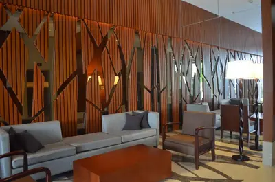 a lobby with a couch and chairs and a wall with bamboo at Eton Parkview in Manila