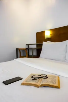a book and glasses sitting on top of a bed at Hotel Durban in Manila