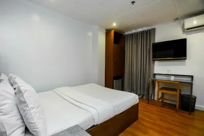 a hotel room with a bed and a flat screen tv at Hotel Durban in Manila