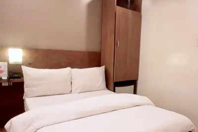 a bedroom with two beds and a wooden headboard at Hotel Durban in Manila