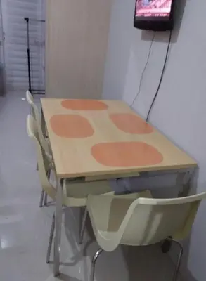 a table with chairs and a television on a wall at Condo At Shell Residences in Manila