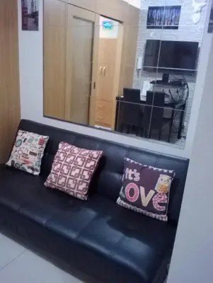 a black couch with pillows on it in a room at Condo At Shell Residences in Manila