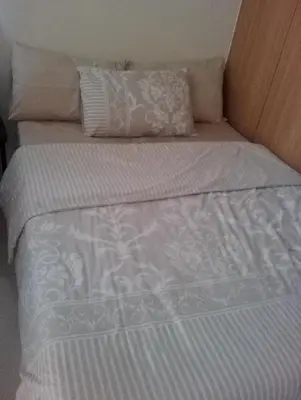 a white bed with two pillows on top of it at Condo At Shell Residences in Manila