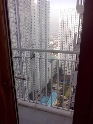a balcony with a view of a pool and buildings at Condo At Shell Residences in Manila