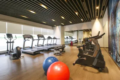 a gym with treadmills and exercise equipment in a room at The Mini Suites Eton Tower Makati in Manila