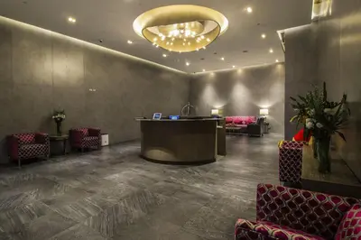 a lobby with a bar and chairs and a chandelier at The Mini Suites Eton Tower Makati in Manila