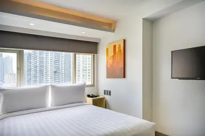 a bedroom with a bed and a flat screen tv at The Mini Suites Eton Tower Makati in Manila