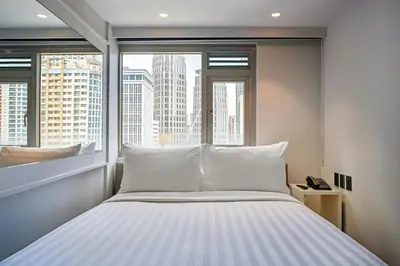 a bed in a room with a large window at The Mini Suites Eton Tower Makati in Manila