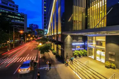 a city street at night with a car on the street at The Mini Suites Eton Tower Makati in Manila