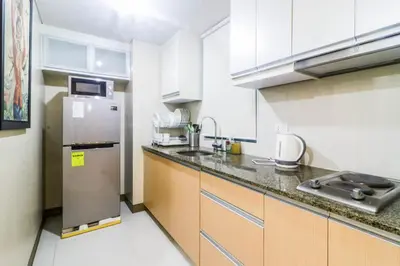 a kitchen with a stainless steel refrigerator and cabinets at PRS at One Palm Tree Villa near T3 Airport in Manila