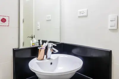a white sink in a bathroom with a mirror at PRS at One Palm Tree Villa near T3 Airport in Manila
