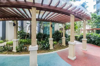 a wooden pergola in front of a building at PRS at One Palm Tree Villa near T3 Airport in Manila