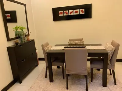 a dining room with a table and chairs at Eastwood Residence Above Eastwood Mall in Manila