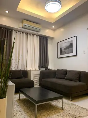 a living room with two couches and a coffee table at Eastwood Residence Above Eastwood Mall in Manila