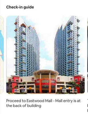 two tall buildings in a city with buildings at Eastwood Residence Above Eastwood Mall in Manila